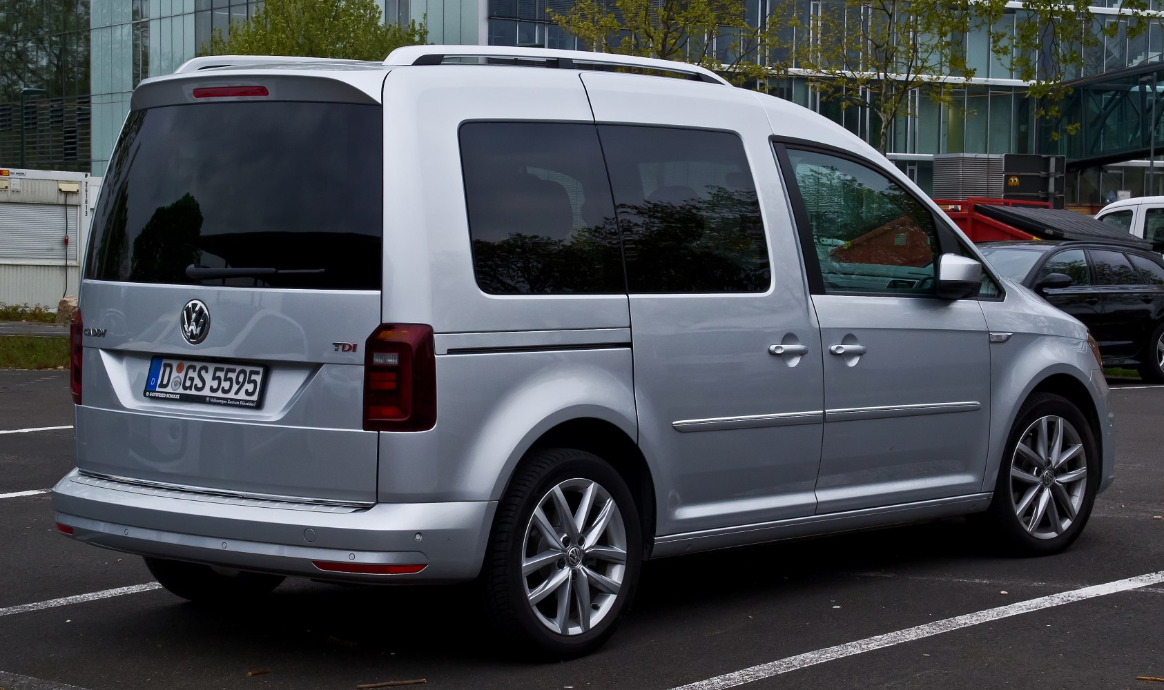 Silver minivan side and rear view with sliding door and tinted windows