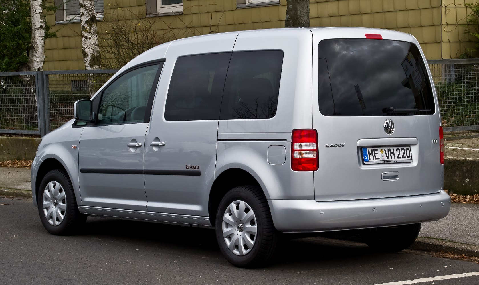 Silver van rear and side view with tinted windows and boxy design