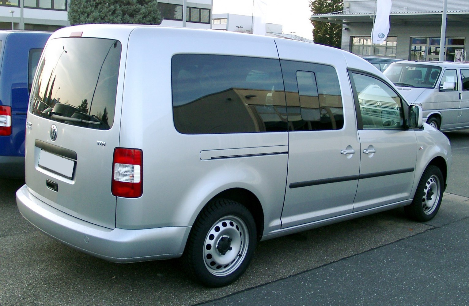 Silver long wheelbase van rear and side view with sliding door and tinted windows