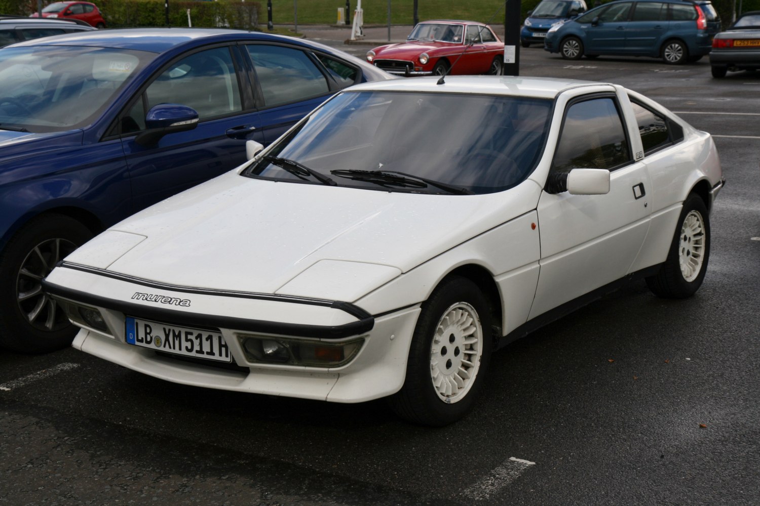 Angular 1980s sports coupe with pop-up headlights and unique multi-spoke wheels