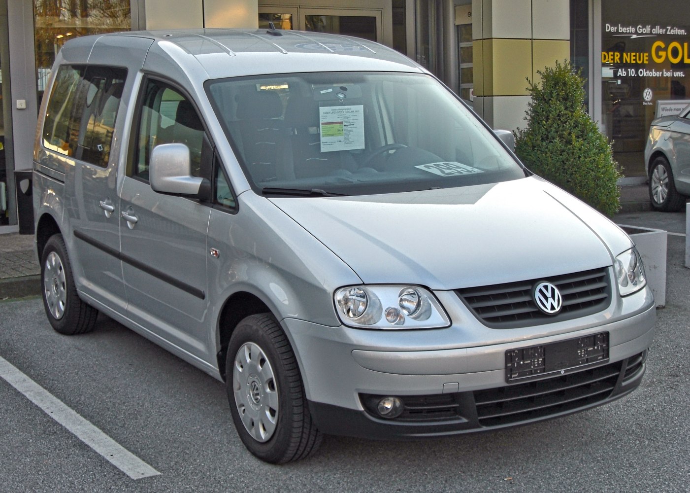 Compact van with sliding side doors and roof rails in silver.