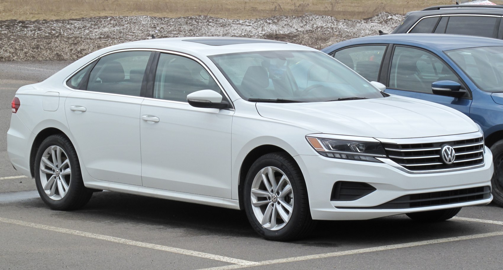 White mid-size sedan with alloy wheels and sunroof in parking lot
