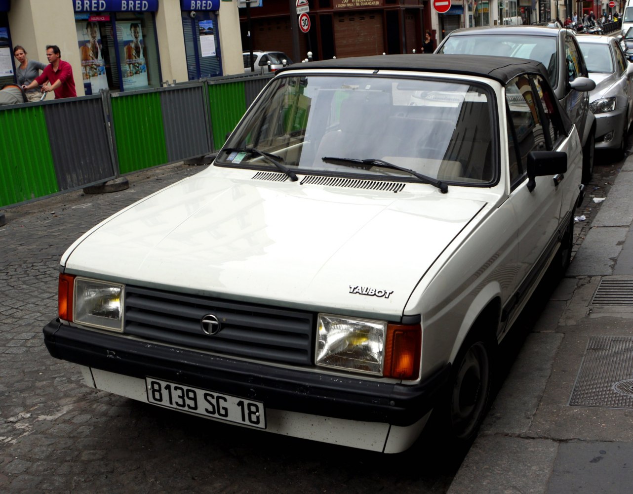 White convertible with black soft top and rectangular headlights
