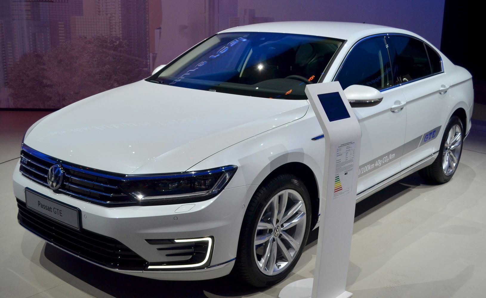 Front side view of white hybrid sedan with LED lights and alloy wheels