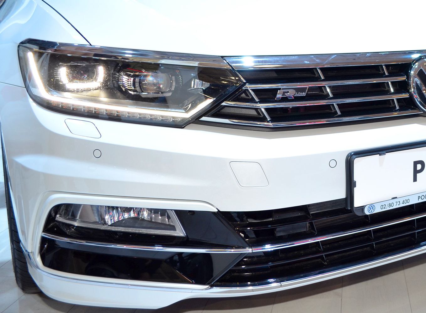 Front LED headlight and R-Line grille on a white vehicle