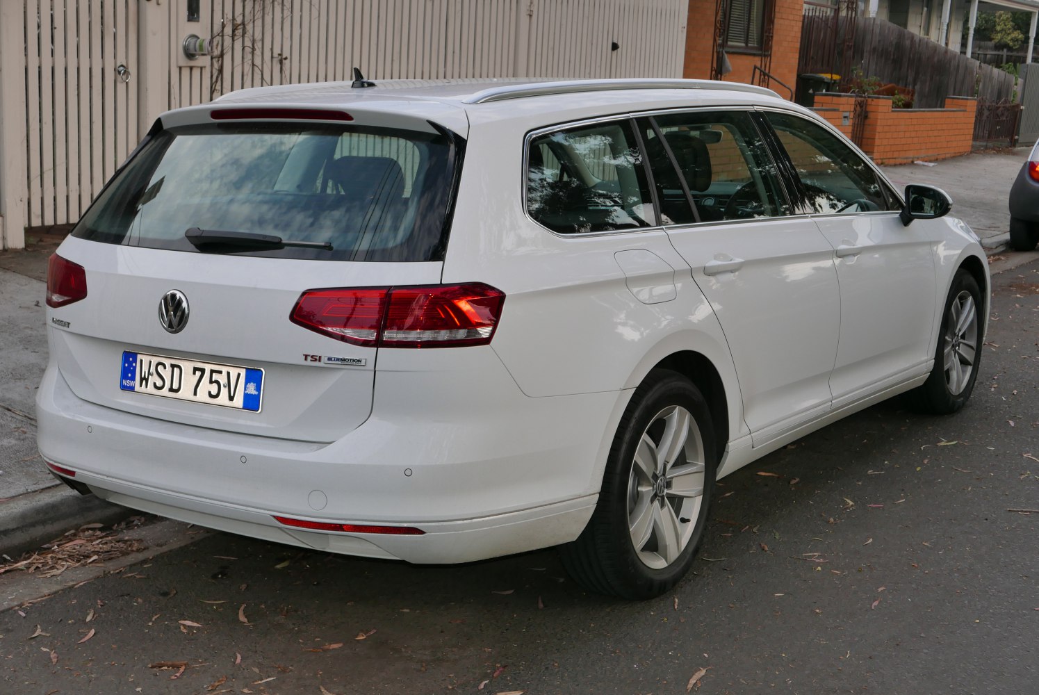White station wagon rear side view with distinct tail lights and alloy wheels