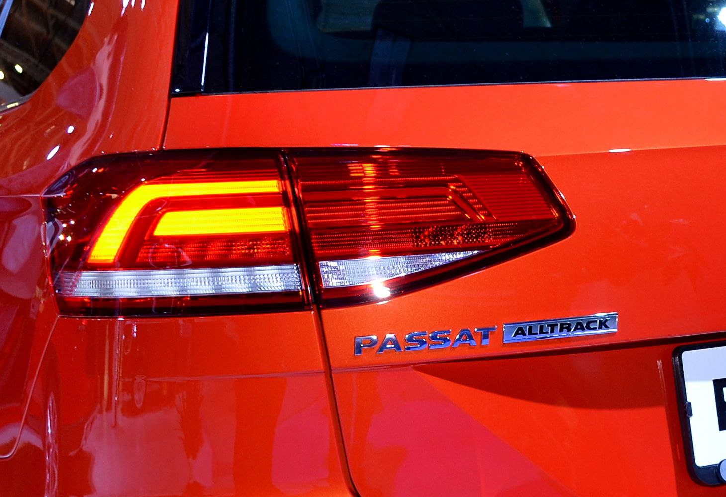 Rear LED tail light and Passat Alltrack badge on orange vehicle