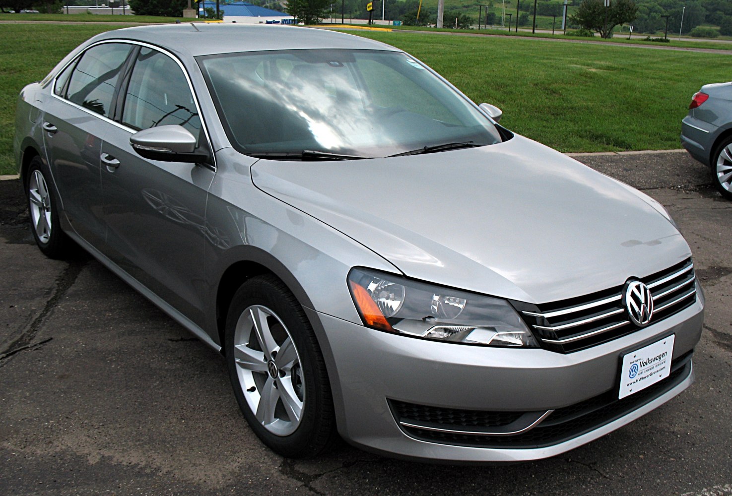 Silver sedan showing front side with headlight and alloy wheels