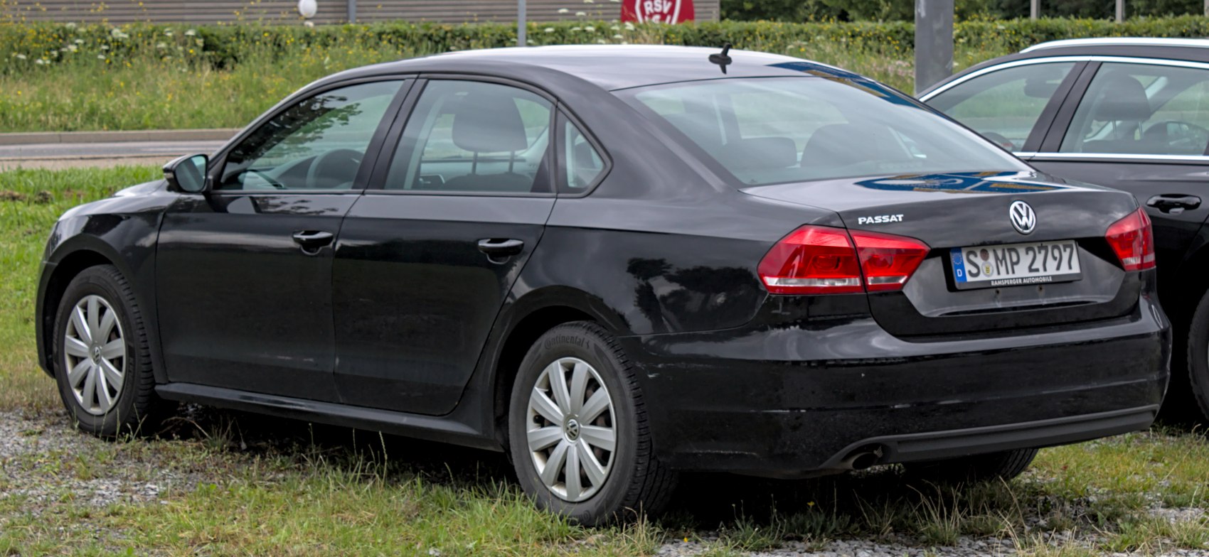 Rear side view of black sedan with distinct taillights and alloy wheels