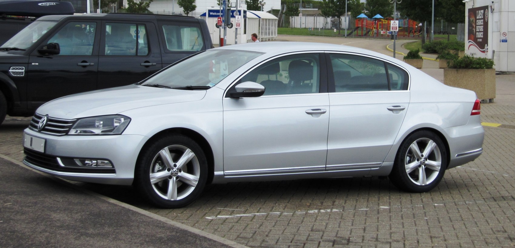 Silver mid-size sedan with sleek profile and five-spoke alloy wheels