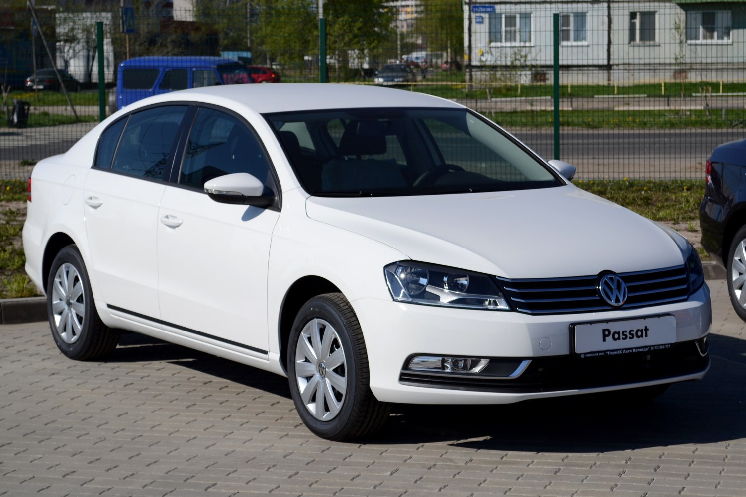 Front three-quarter view of white midsize sedan with distinct headlamps