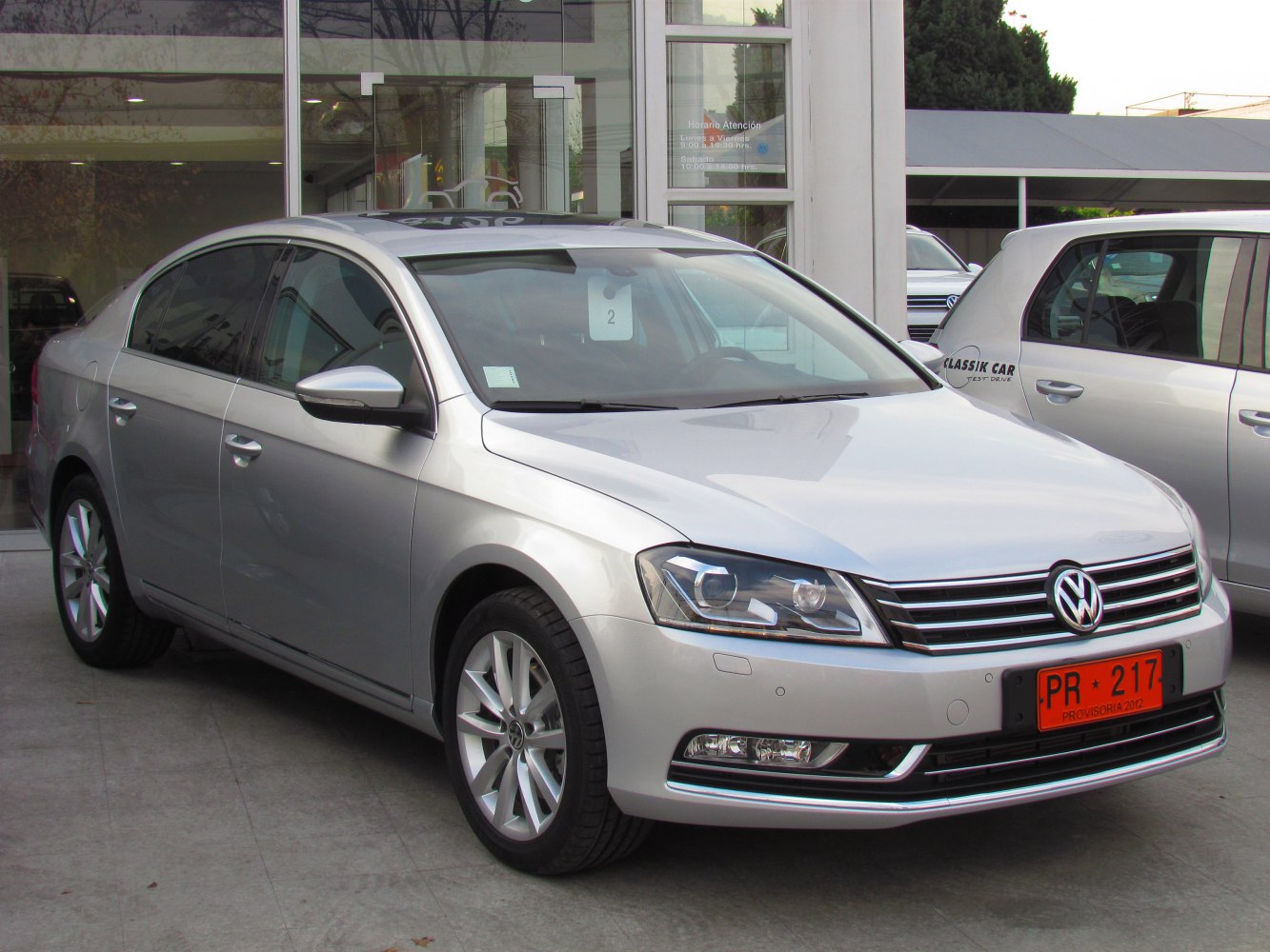 Front view of silver sedan with LED headlights and chrome grille