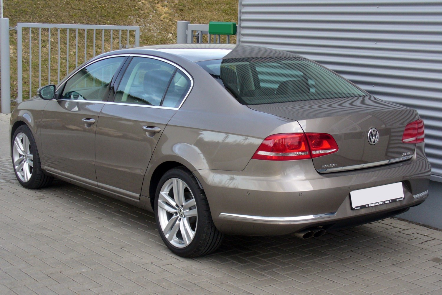 Rear side of a sedan with alloy wheels and red taillights