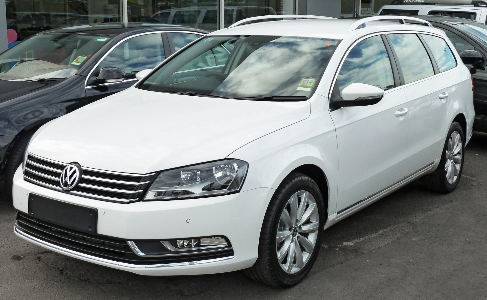 White mid-size station wagon with alloy wheels and roof rails