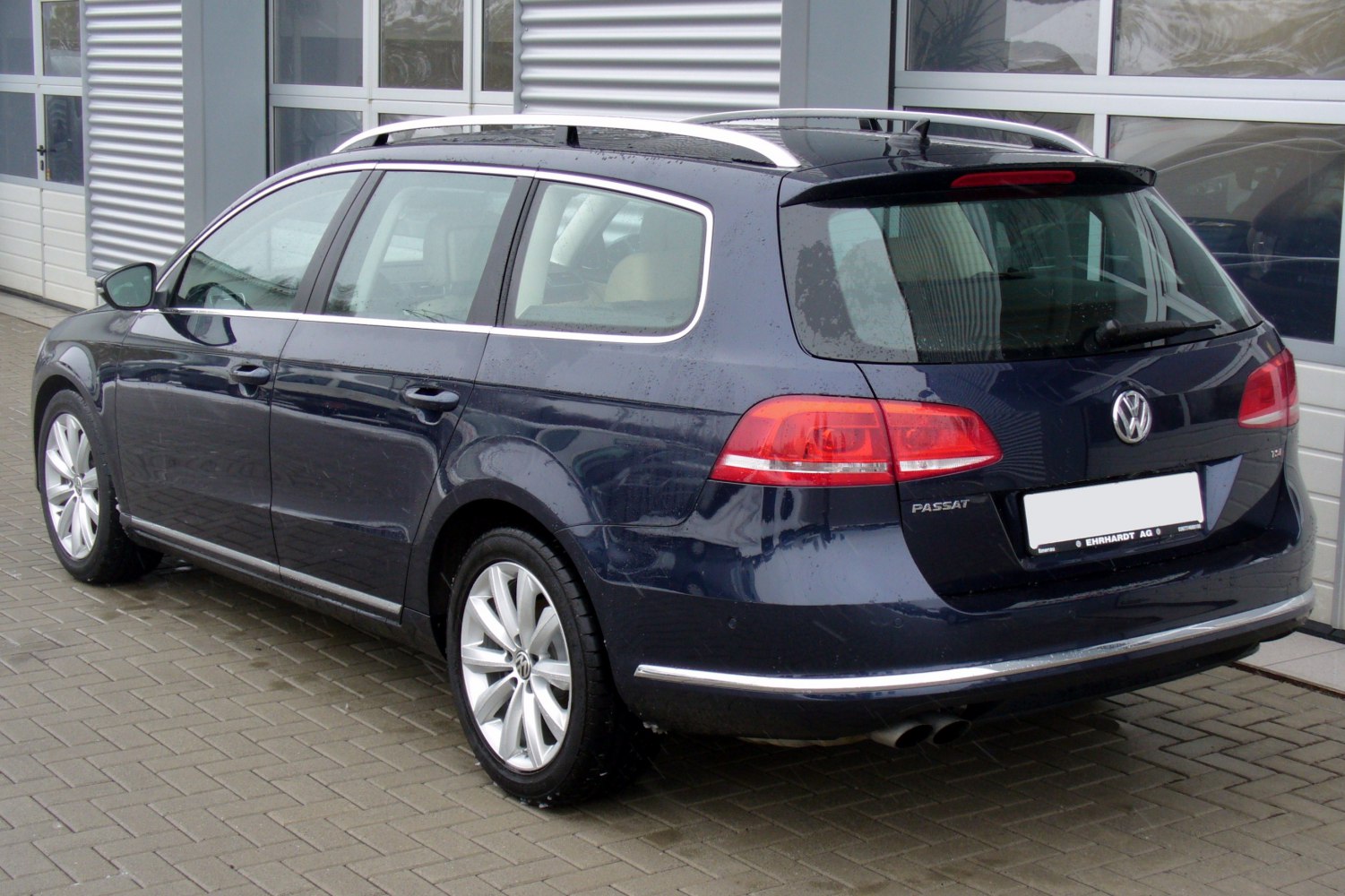 Rear and side view of a station wagon with dual exhaust and roof rails