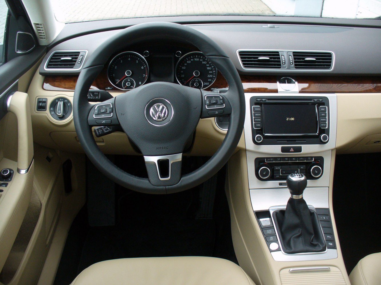 Dashboard, steering wheel, manual gear shift, and center console with wood trim