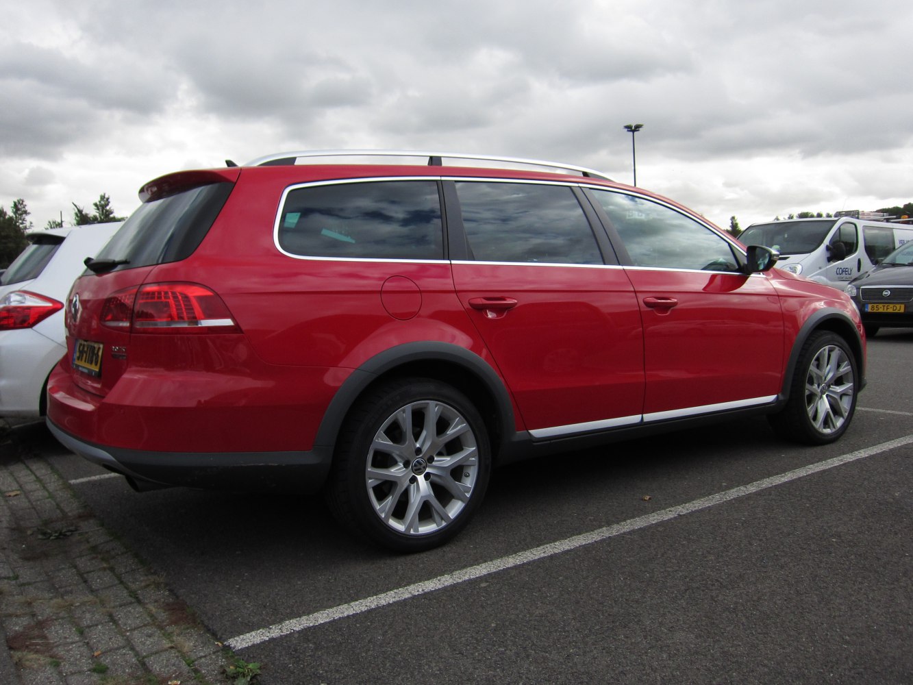 Red wagon with alloy wheels and roof rails side-rear view
