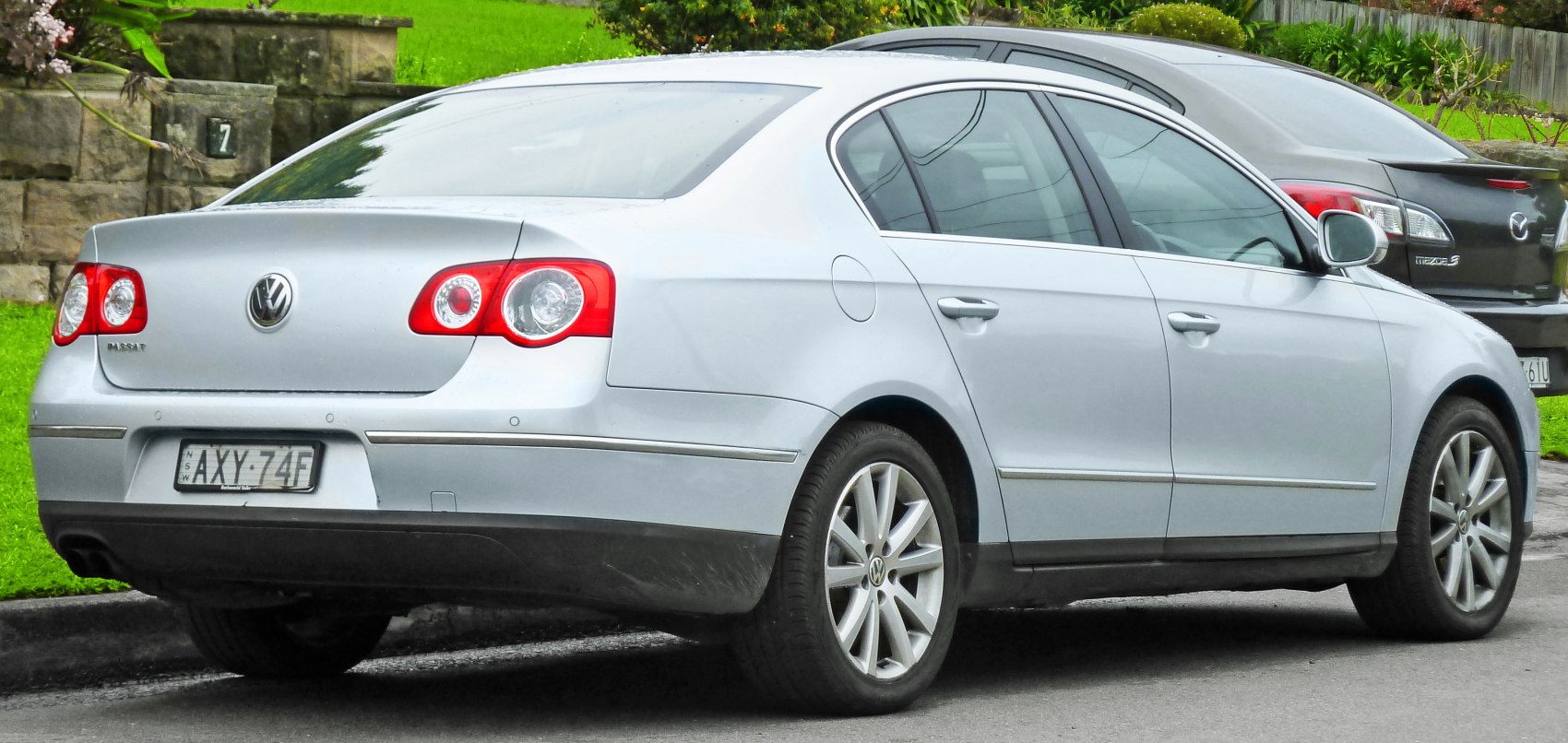 Silver sedan rear with round tail lights and multi-spoke alloy wheels