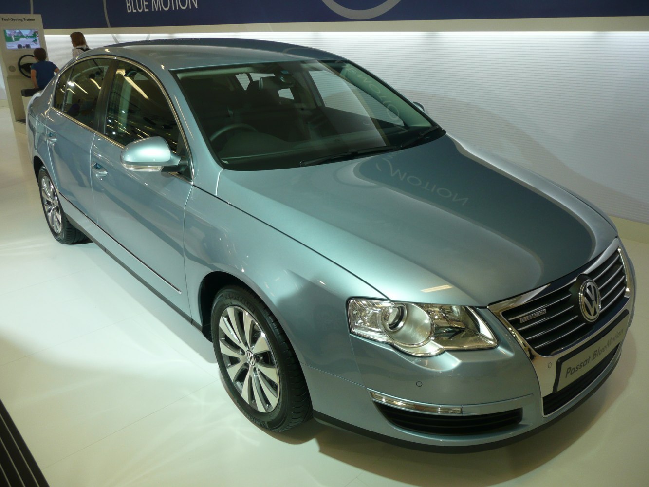 Front and side view of mid-size sedan with blue metallic paint and alloy wheels