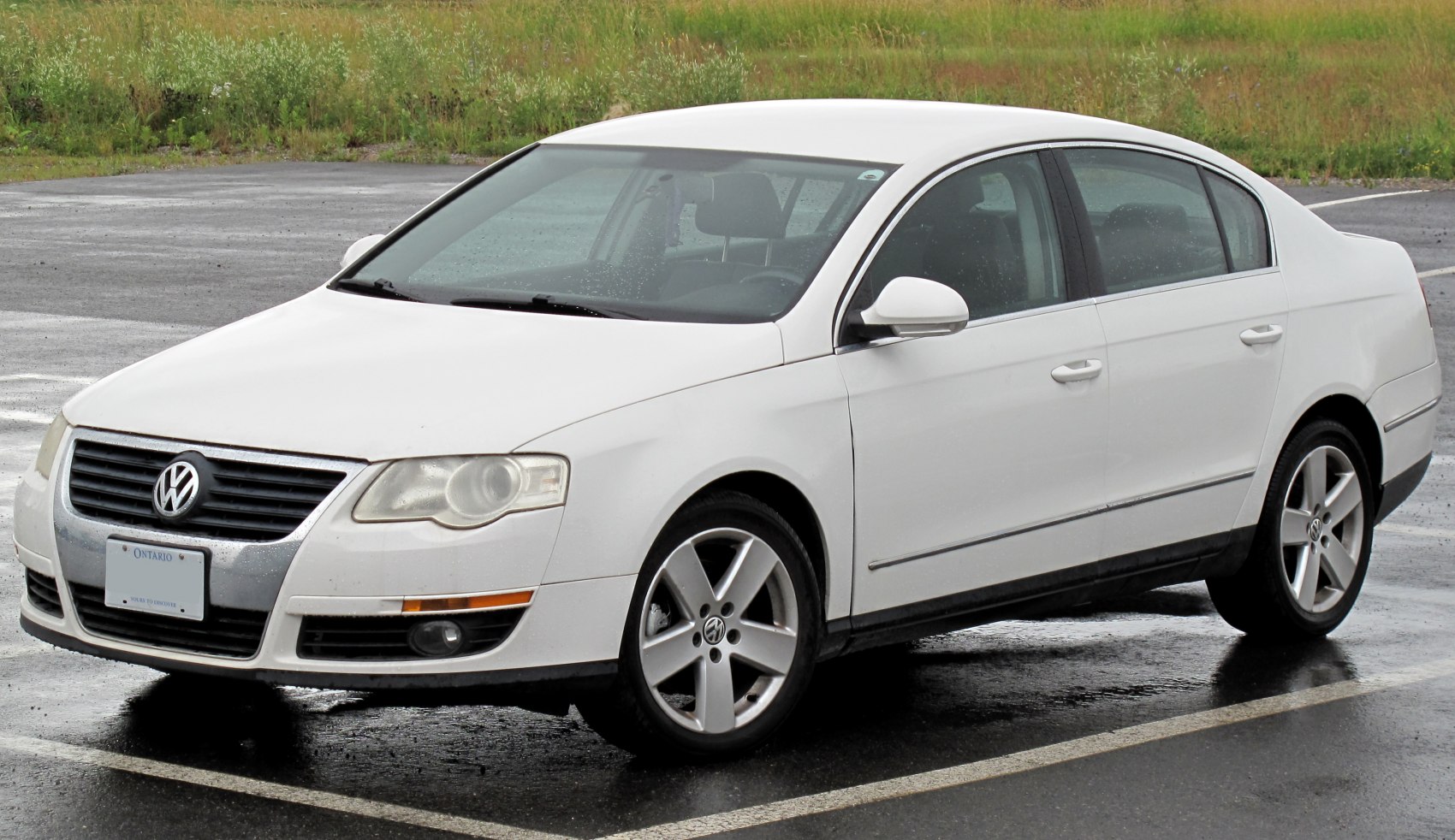 White sedan with front side view, alloy wheels, and distinctive grille.