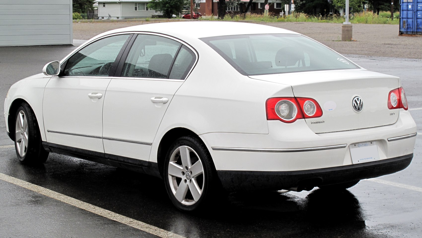 Rear side view of white mid-size sedan with distinct taillights and alloy wheels