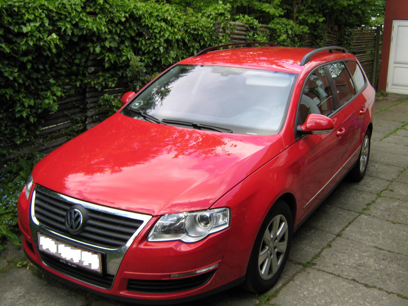 Red station wagon front with grille, headlights, and roof rails