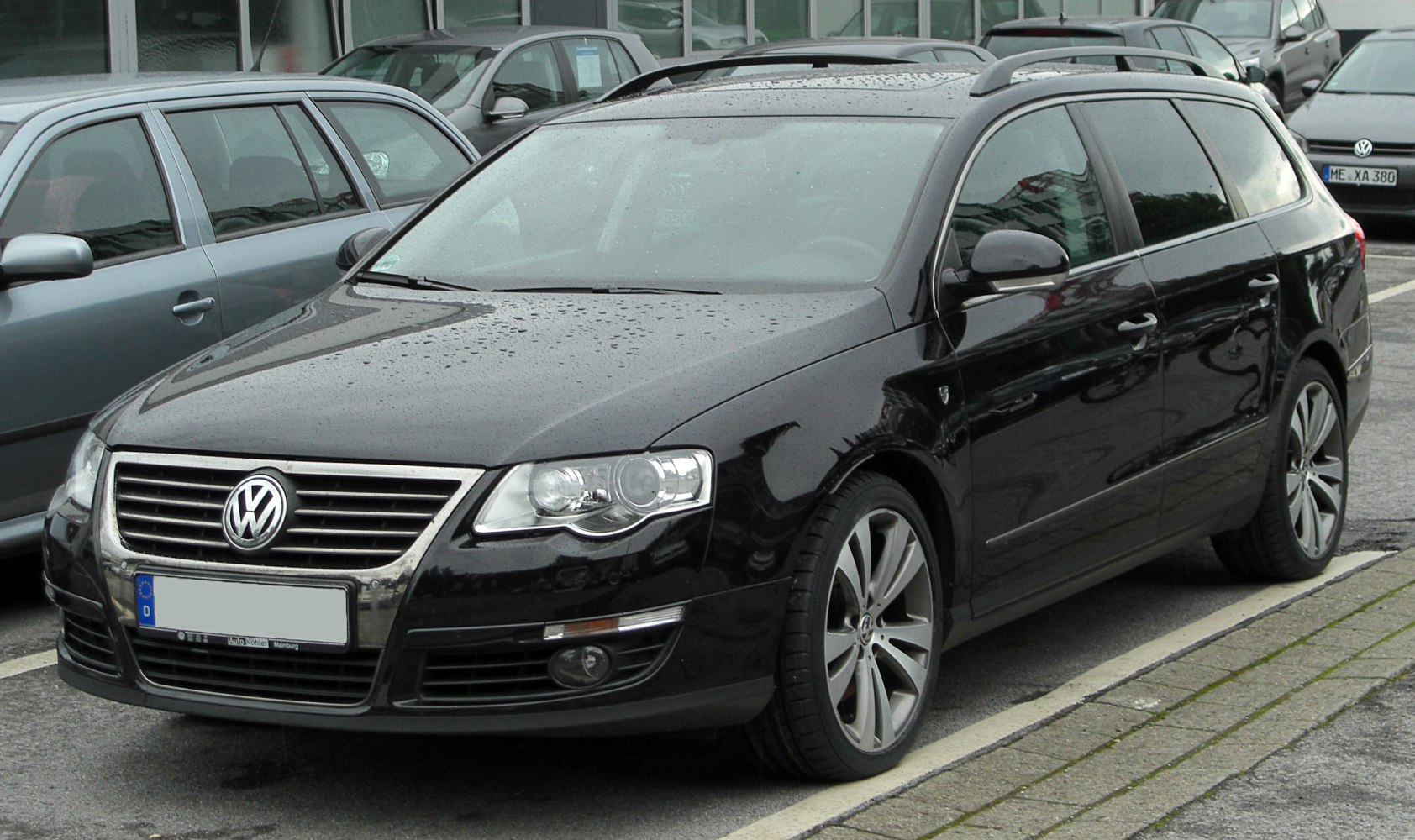 Black station wagon with roof rails and alloy wheels.