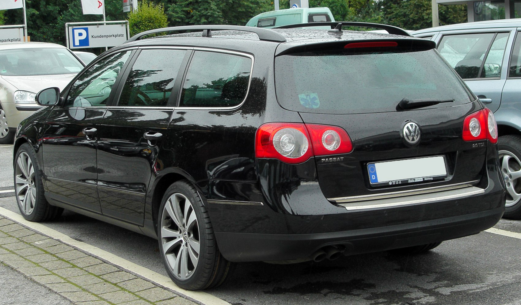Black station wagon rear with roof rails and dual exhaust