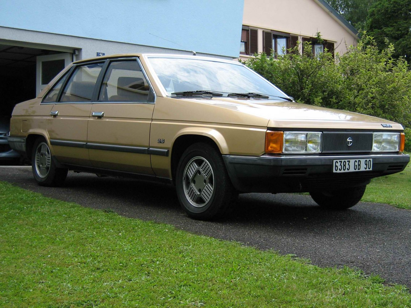 Angular sedan with distinctive front grille and vintage wheel covers