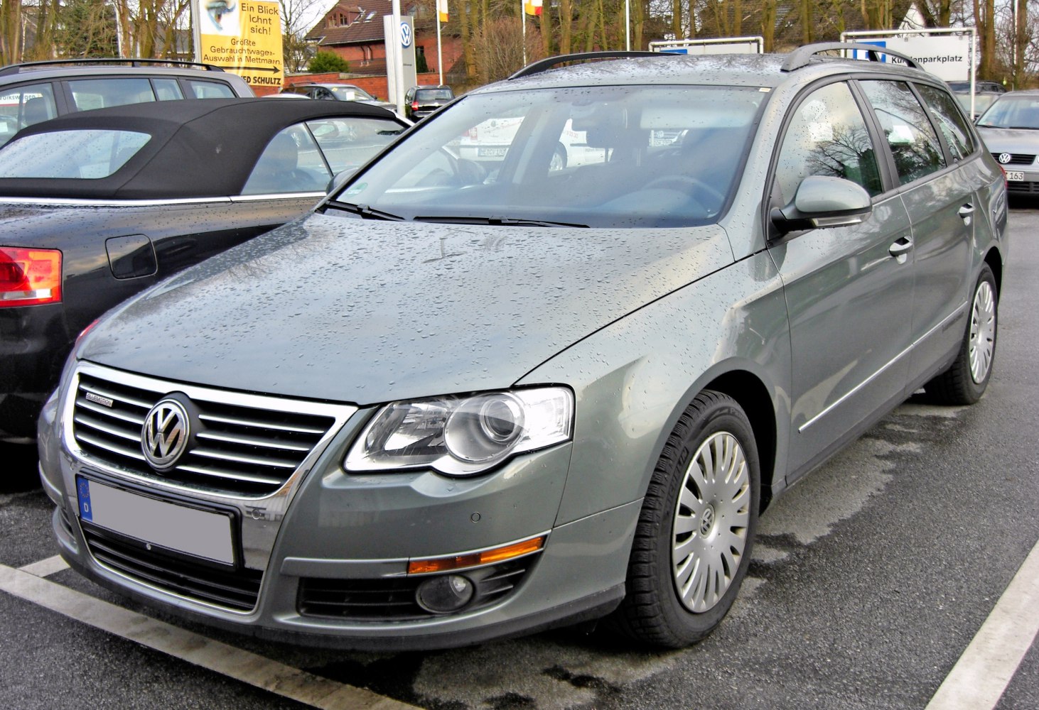 Front-side view of wet Volkswagen Passat Variant B6 with headlights and grille visible