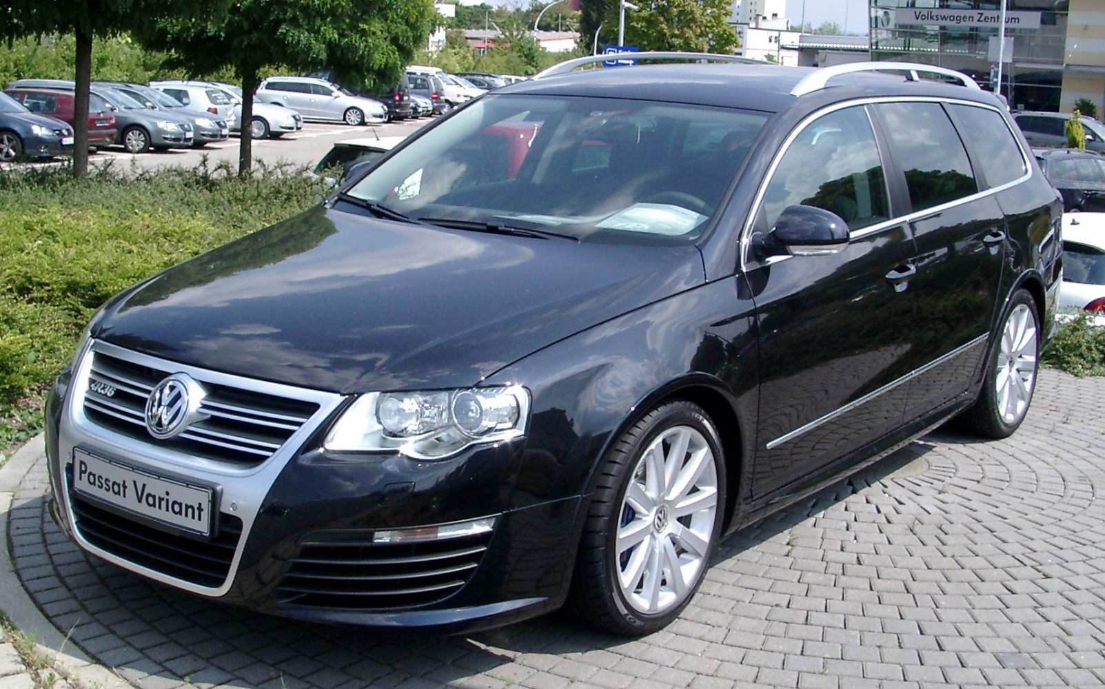 Front and side view of an estate car with alloy wheels and chrome trim.
