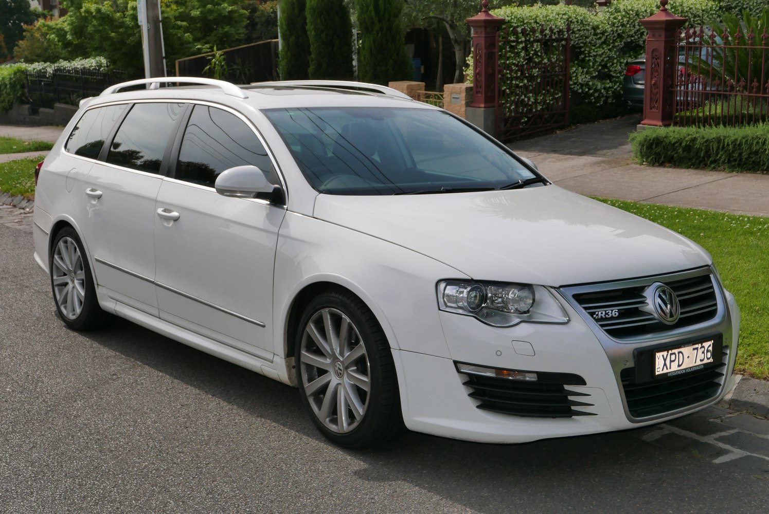 Front-side view of white station wagon with alloy wheels and roof rails
