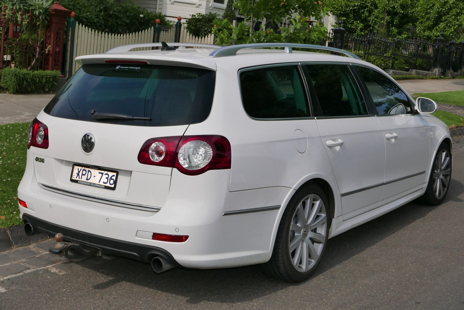 Rear view of white station wagon with roof rails and rear spoiler
