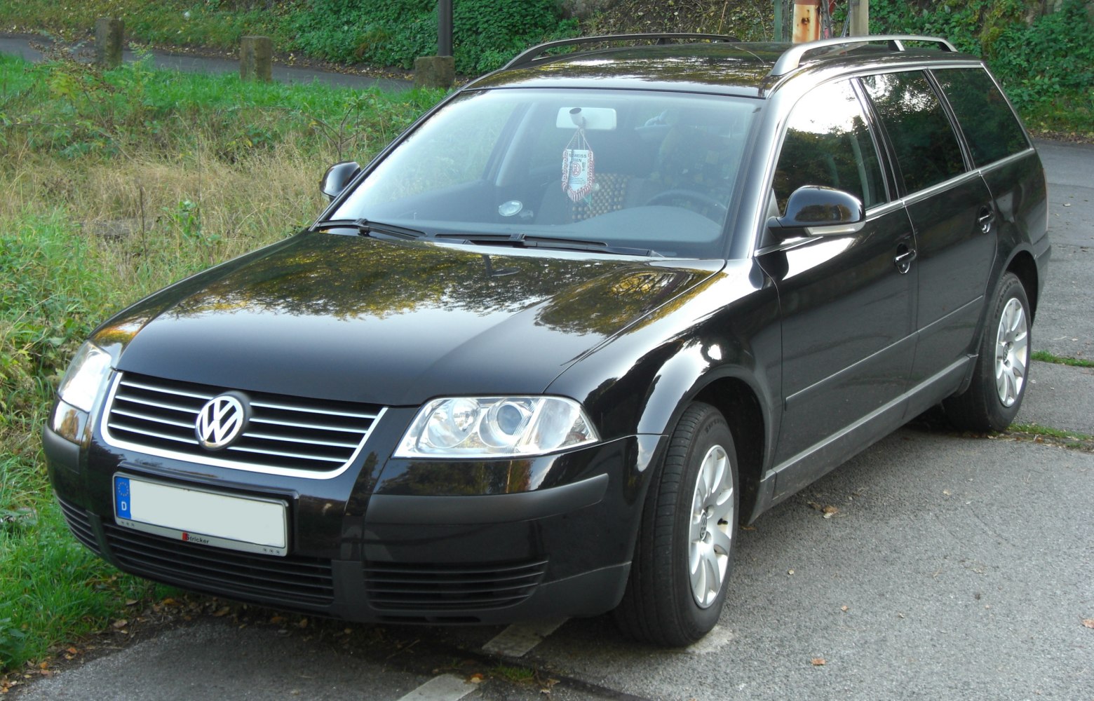 Front and side view of black station wagon with roof rails and headlight