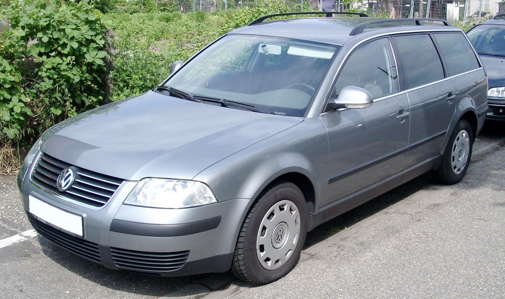 Silver station wagon front side view with roof rails and classic wheel covers