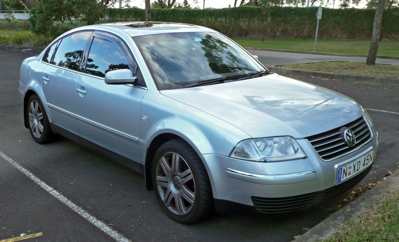 Silver four-door sedan with prominent headlights and chrome grille bars