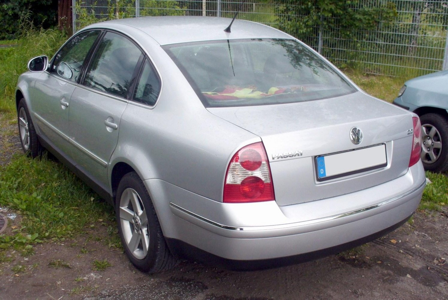 Rear 3/4 view of silver sedan with round tail lights and alloy wheels