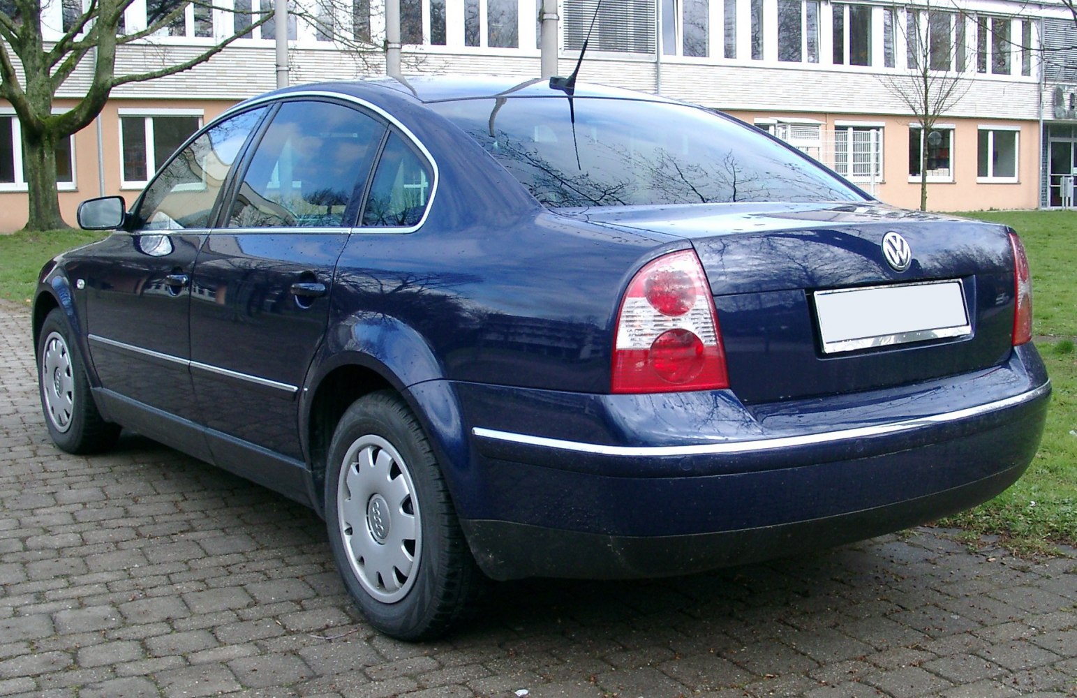 Rear and side profile of a blue sedan with distinctive taillights and chrome trim