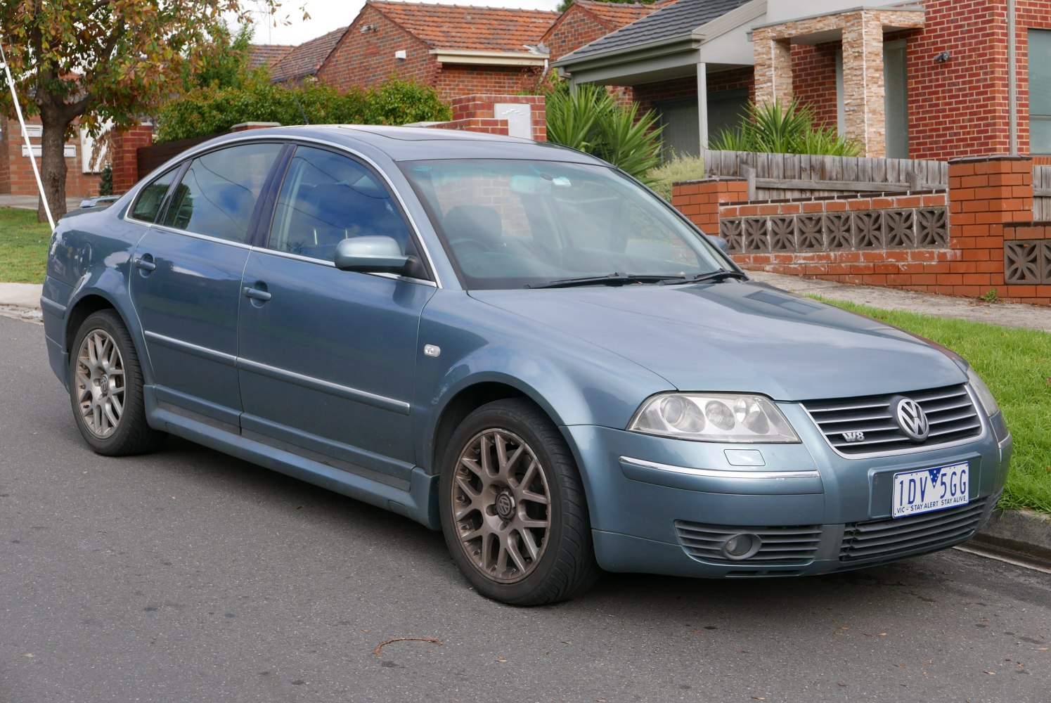 Front-side of a sedan with alloy wheels and dual headlights