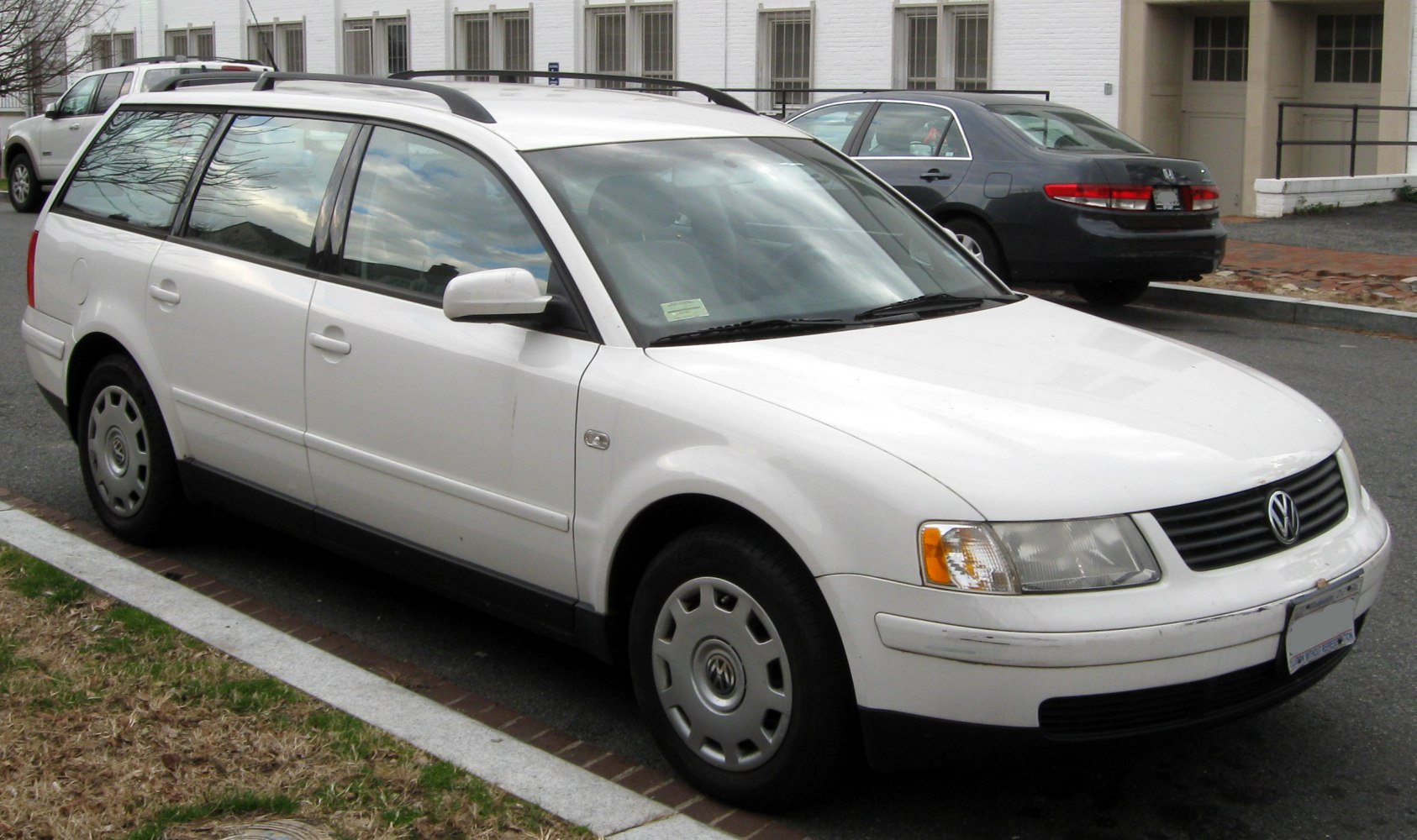 White estate car front-side view with roof rails.
