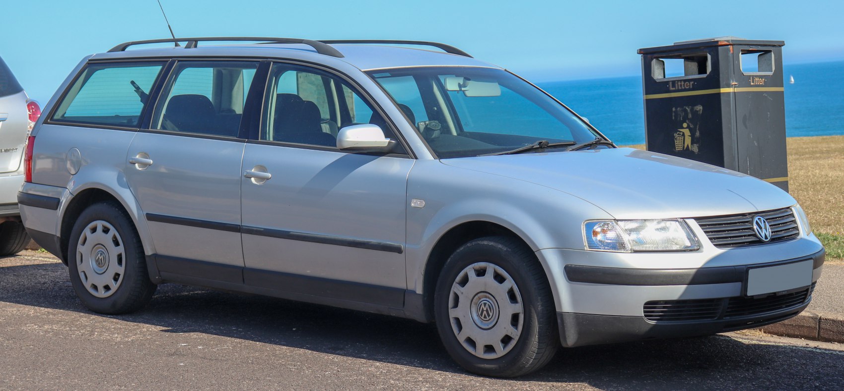 Side view of a silver station wagon with roof rails.