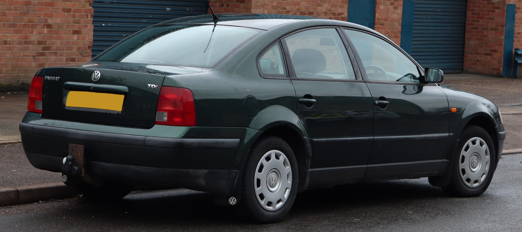Rear side view with TDI badge and tow hitch on dark green sedan