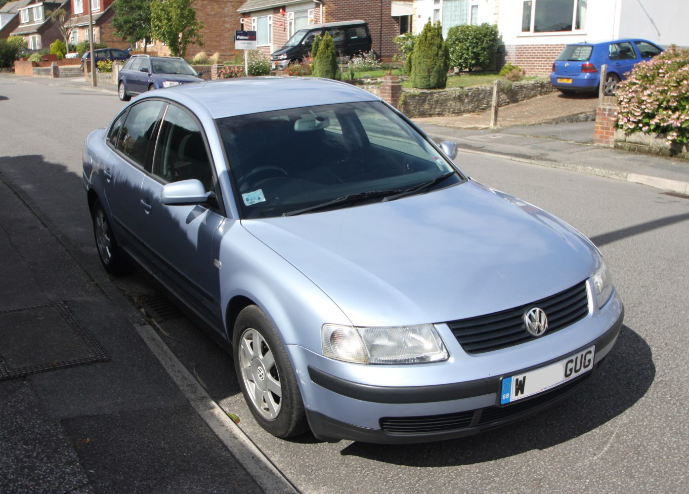 Front-angle view of a 1990s four-door sedan parked on a street