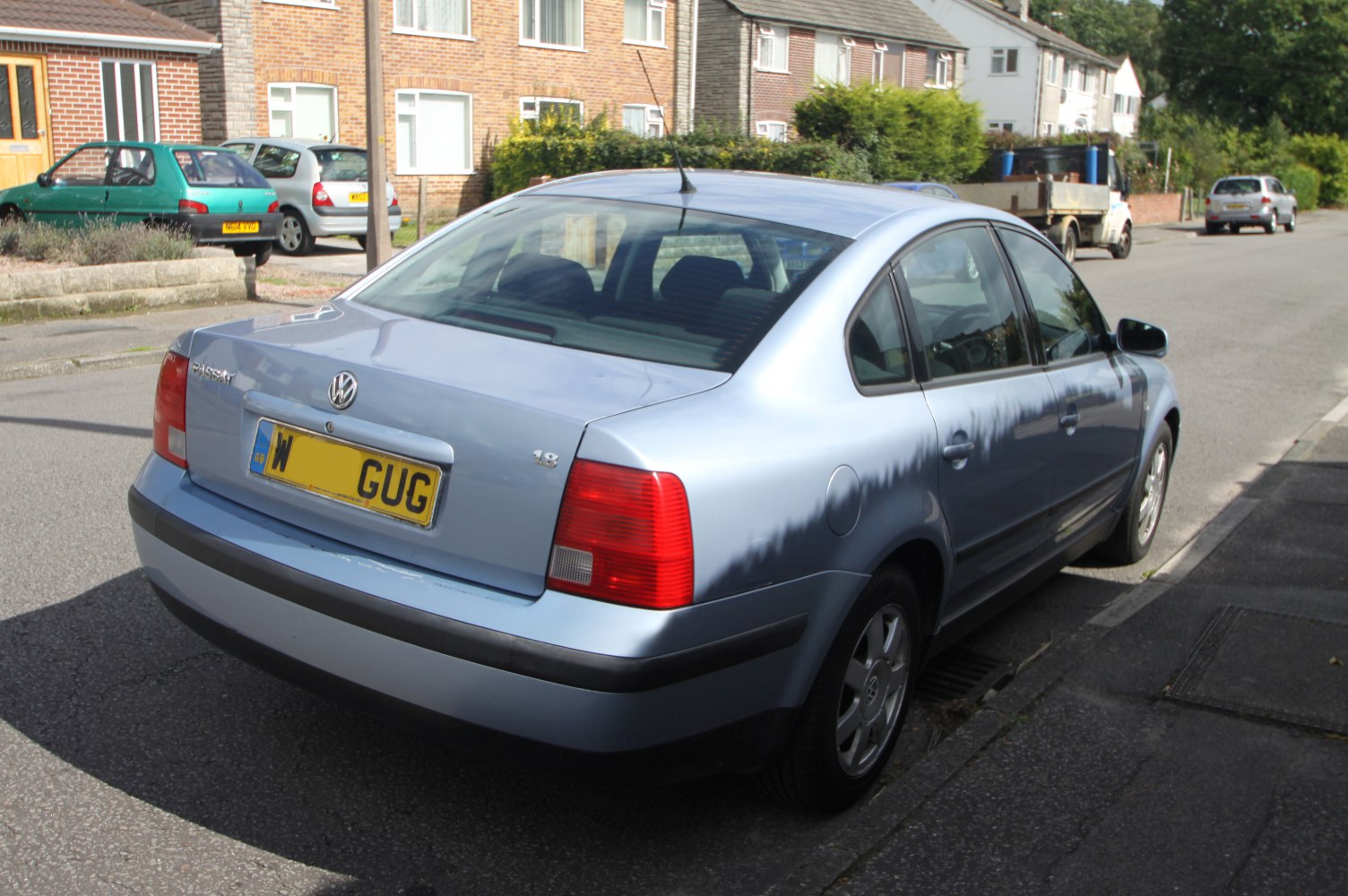 Rear view of light blue sedan with 1.8 badge and classic tail lights