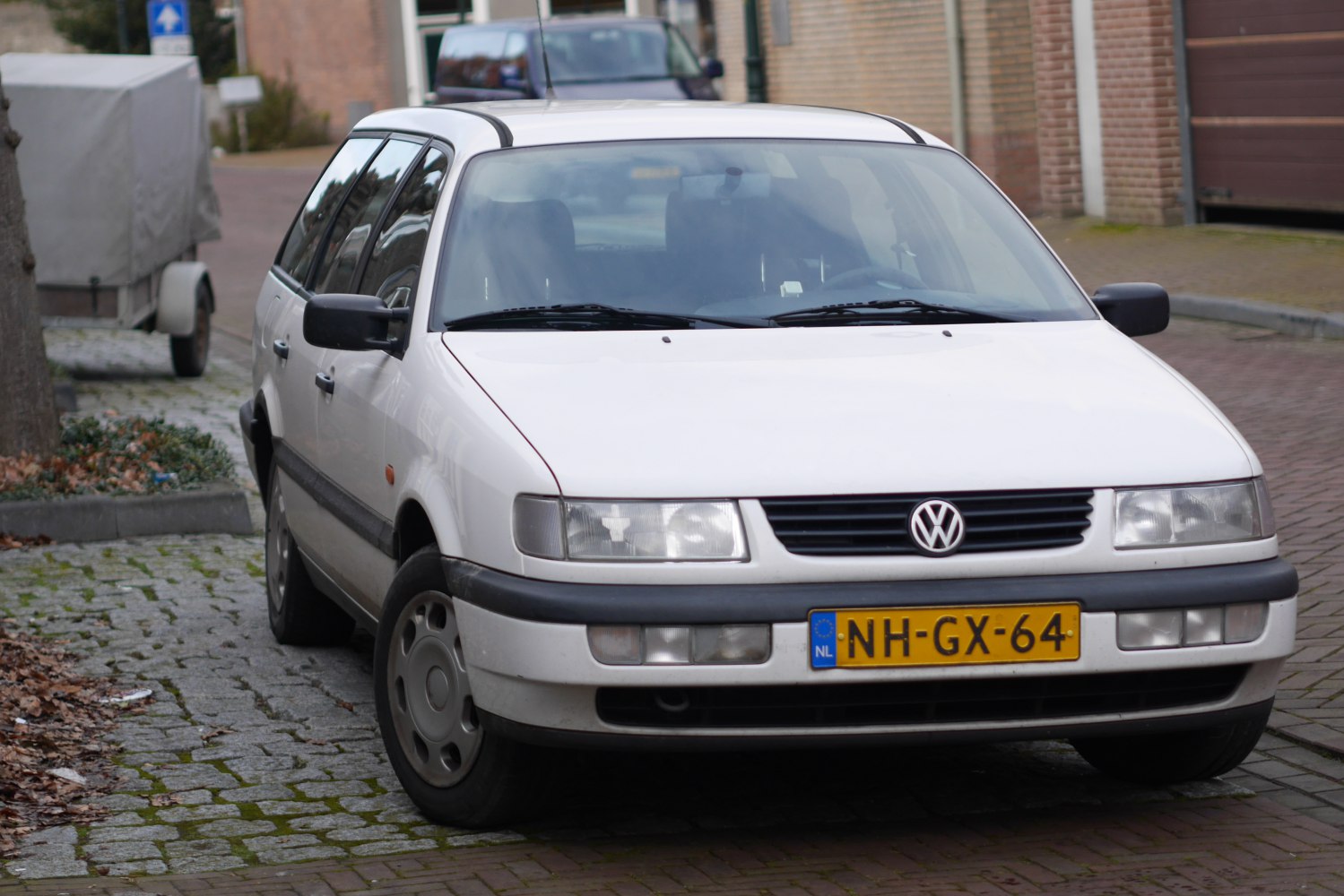 Front and side view of a white wagon with classic rectangular headlights and black trim.