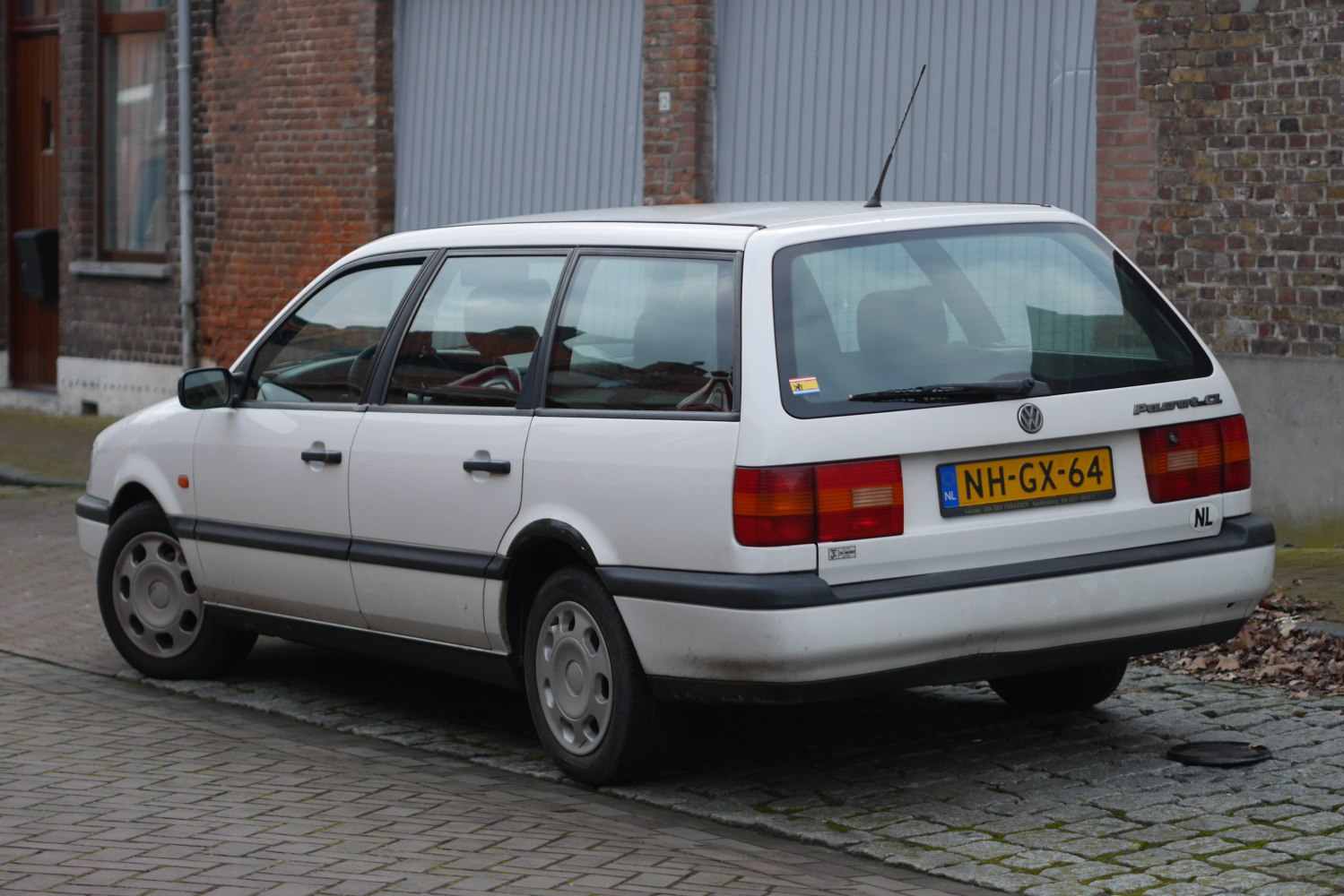 Rear-side view of a white station wagon with classic taillights