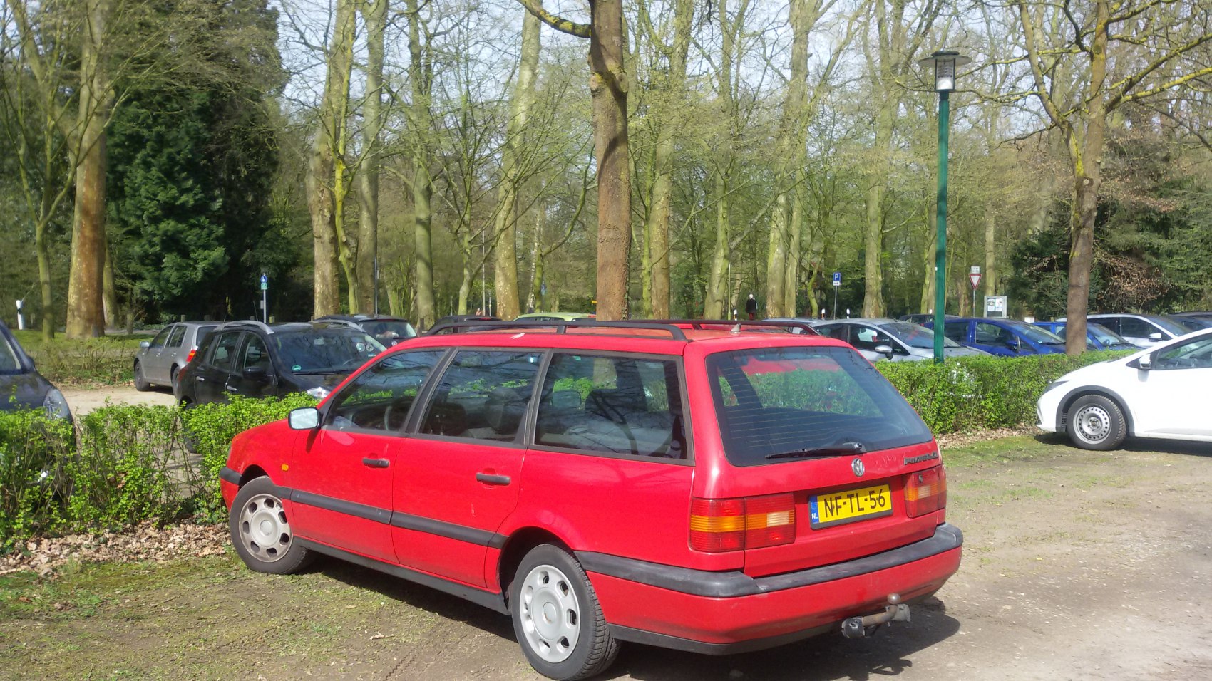Rear side view of red station wagon with roof rails