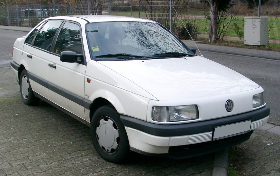 Front and side view of a white sedan with rectangular headlights and black trim