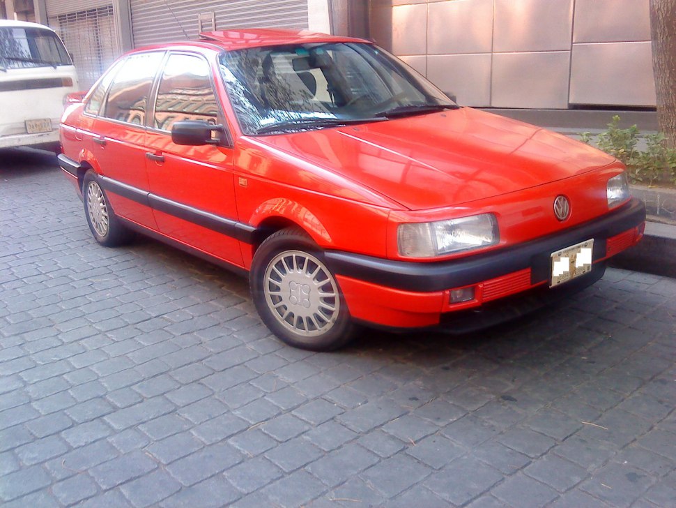 Red sedan with boxy design, black bumper, alloy wheels, front-side angle