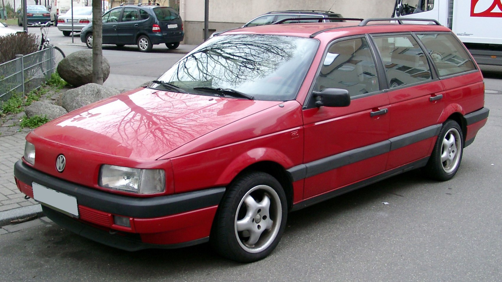 Red compact station wagon with black trim and rectangular headlights.
